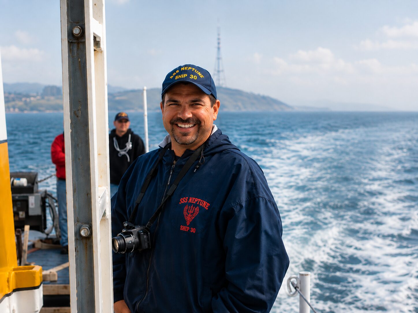 Nate Eckler aboard the Sea Scout ship Neptune under way, in a Neptune cap and jacket with a camera around his neck